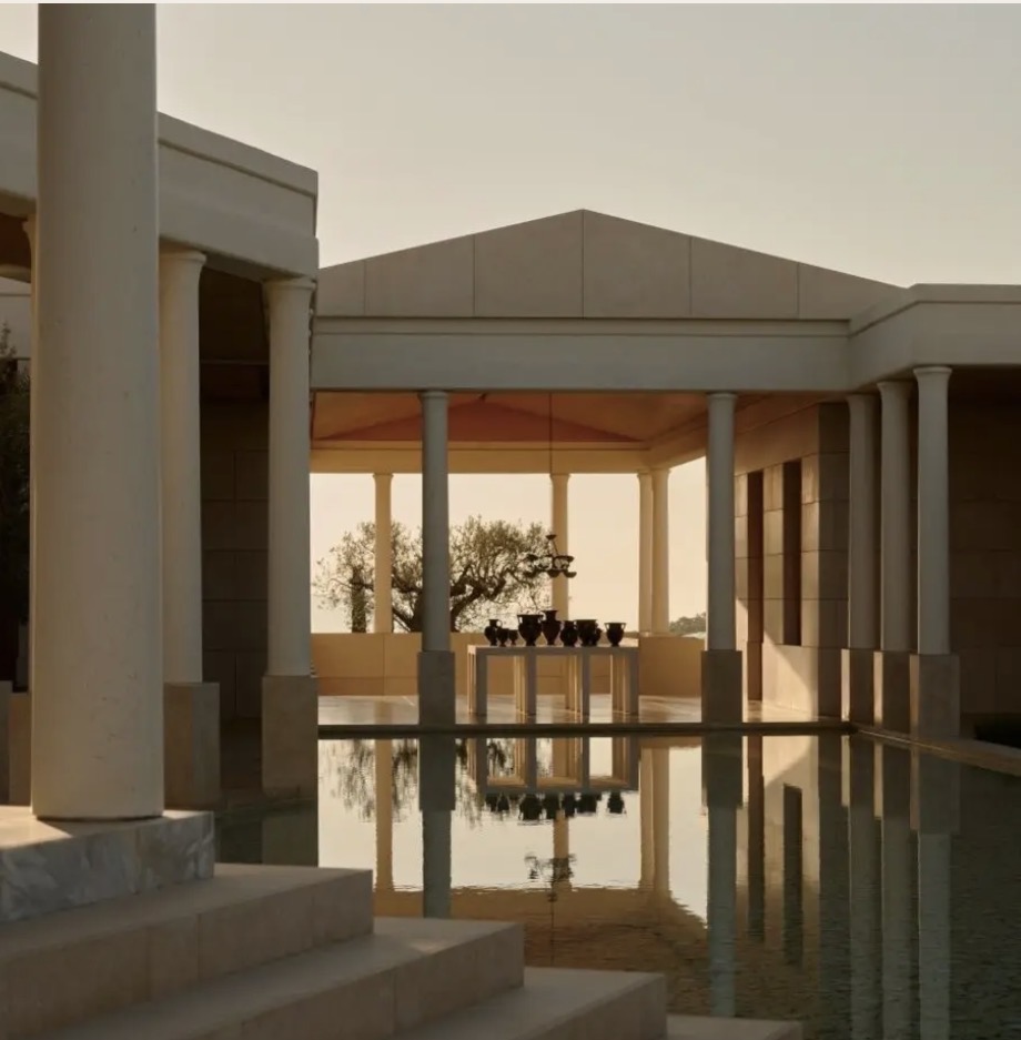 A colonnade reflected in a still pool at dusk